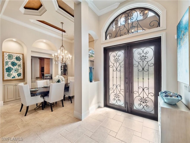 entrance foyer with ornamental molding and a chandelier