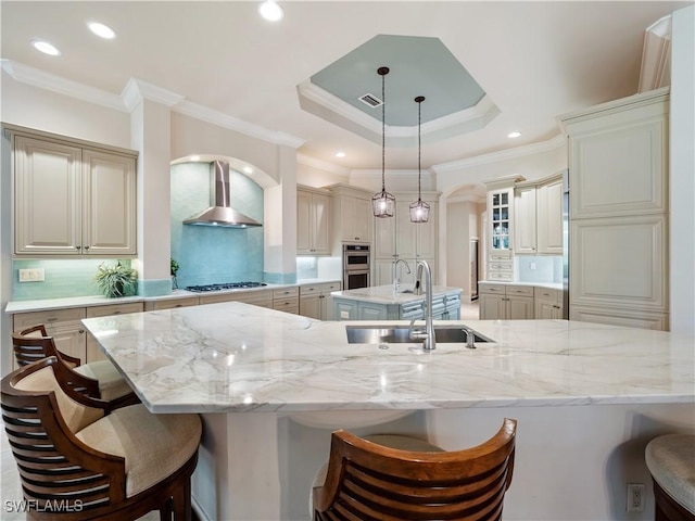 kitchen featuring sink, a kitchen breakfast bar, and wall chimney exhaust hood