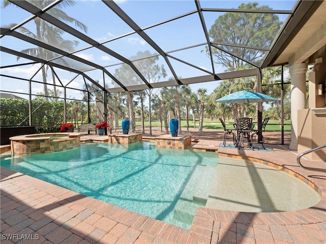 view of pool featuring an in ground hot tub, pool water feature, a patio area, and glass enclosure