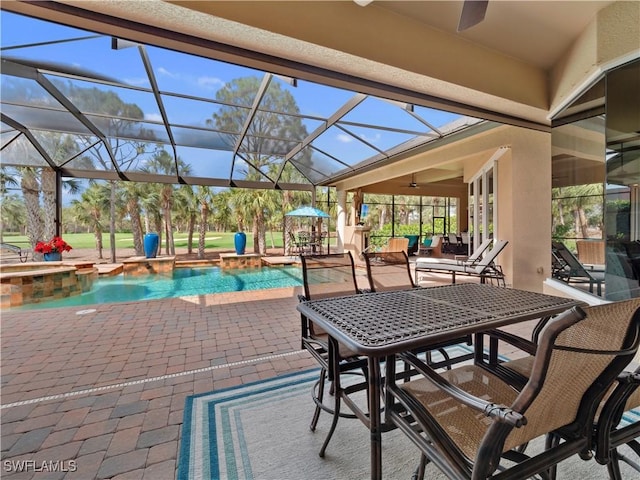 view of patio with a lanai, ceiling fan, and a pool with hot tub