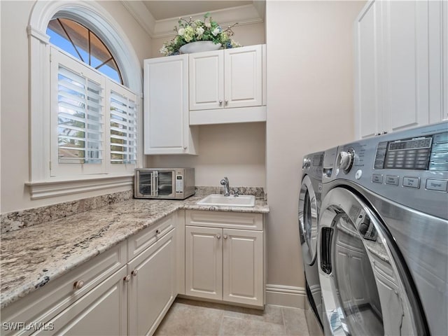 washroom featuring sink, cabinets, light tile patterned floors, crown molding, and washer and clothes dryer