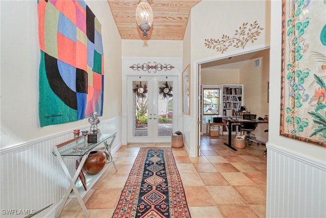 entrance foyer with wood ceiling, a towering ceiling, and french doors