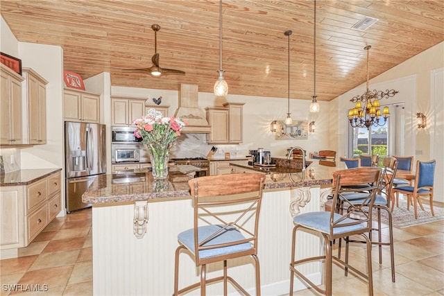 kitchen with appliances with stainless steel finishes, a kitchen island with sink, and dark stone countertops