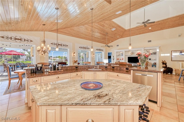 kitchen featuring light stone countertops, hanging light fixtures, and a center island with sink