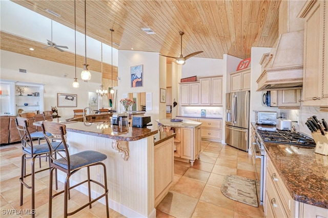 kitchen with stainless steel appliances, a kitchen island, dark stone countertops, and decorative light fixtures