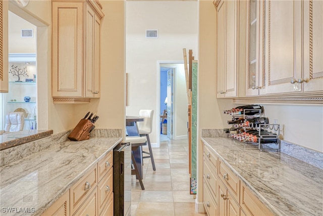 kitchen featuring light tile patterned flooring, light brown cabinetry, and light stone counters