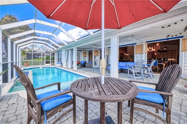 view of pool featuring an outdoor living space, a lanai, a patio area, and ceiling fan