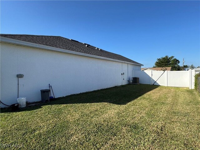 view of home's exterior with a yard, fence, and central AC unit