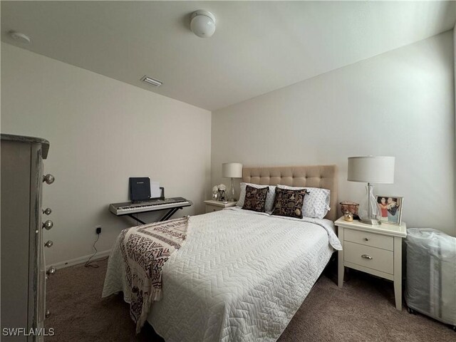 bedroom featuring dark colored carpet, visible vents, and baseboards