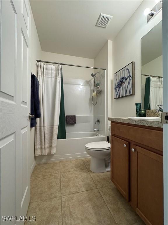 bathroom featuring visible vents, toilet, tile patterned floors, shower / bath combination with curtain, and vanity