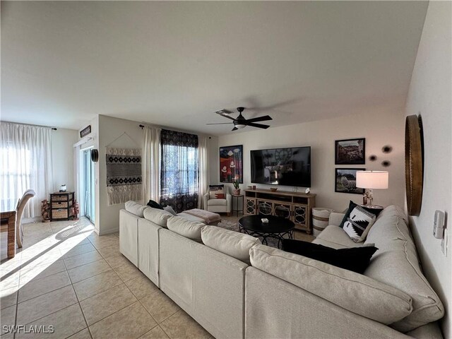 living area featuring a healthy amount of sunlight, ceiling fan, and light tile patterned floors