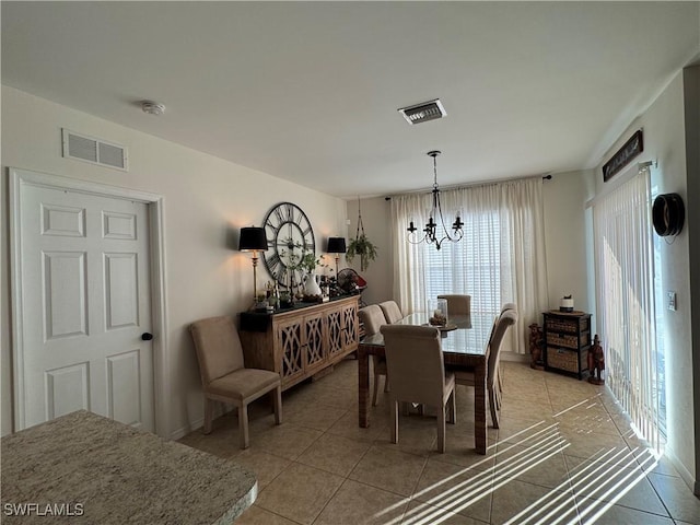 dining space featuring light tile patterned floors, visible vents, and a notable chandelier