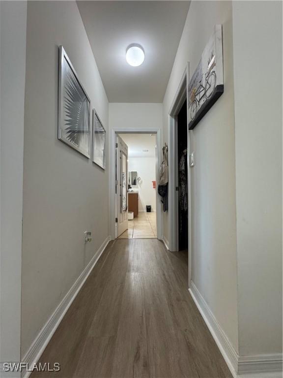 hallway featuring wood finished floors and baseboards