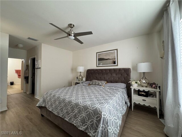 bedroom with a ceiling fan, visible vents, and wood finished floors