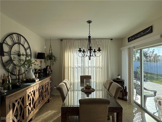 dining space featuring a water view, an inviting chandelier, and light tile patterned floors