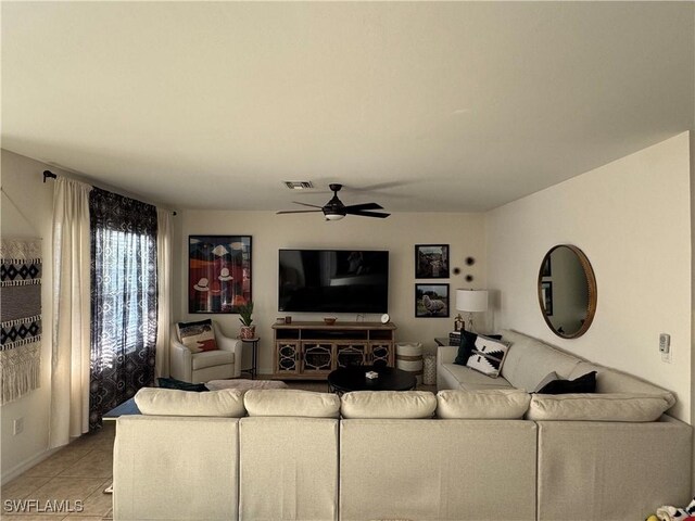 living area featuring light tile patterned floors, ceiling fan, and visible vents