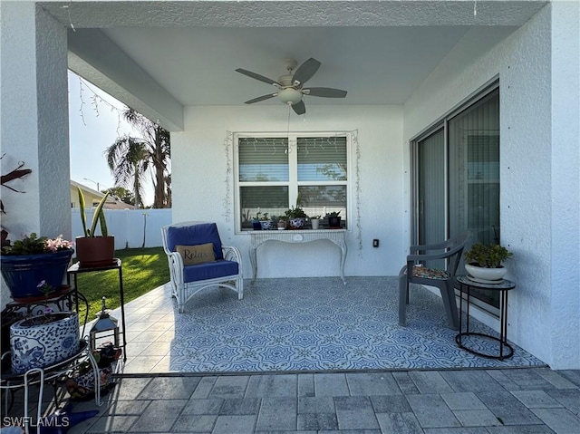 view of patio / terrace with ceiling fan and fence