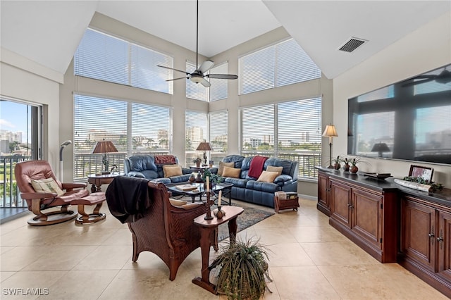 tiled living room featuring plenty of natural light, ceiling fan, and a high ceiling