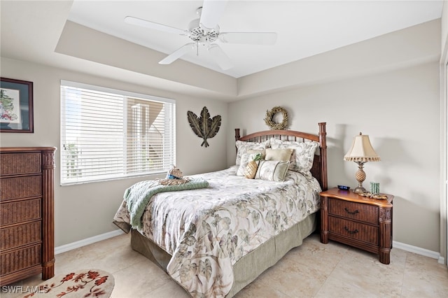 bedroom featuring a raised ceiling and ceiling fan