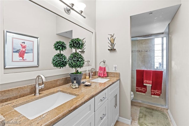 bathroom featuring toilet, vanity, and a shower with door