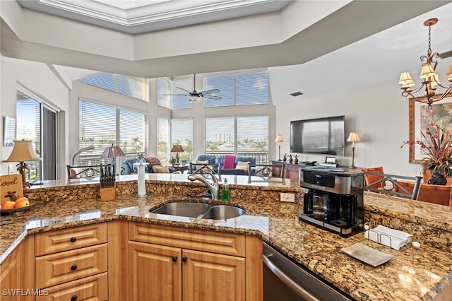 kitchen with ceiling fan with notable chandelier, sink, stone countertops, and dishwasher