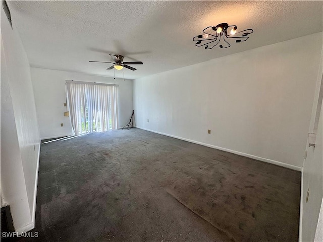 empty room with ceiling fan, a textured ceiling, and dark colored carpet