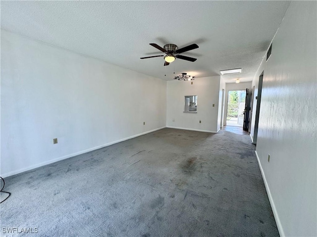 empty room featuring ceiling fan, dark carpet, and a textured ceiling