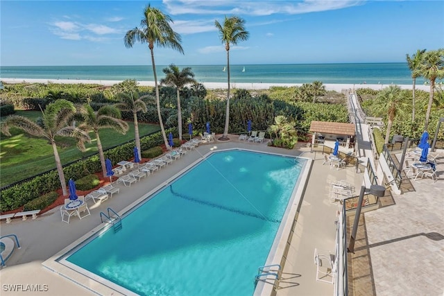 view of pool with a view of the beach, a water view, and a patio area