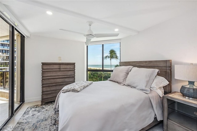 bedroom with ceiling fan, light tile patterned floors, and a wall of windows