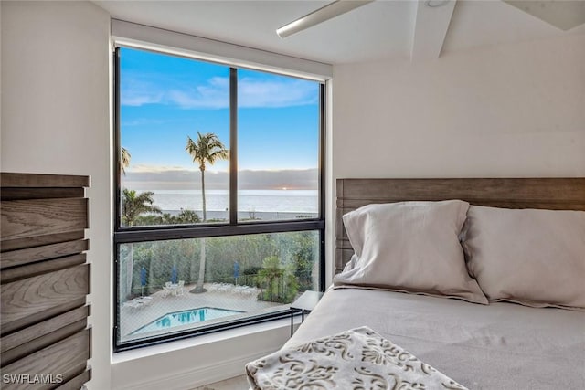 bedroom featuring floor to ceiling windows and a water view