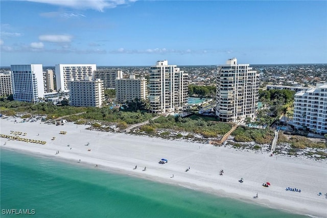 birds eye view of property with a water view and a beach view