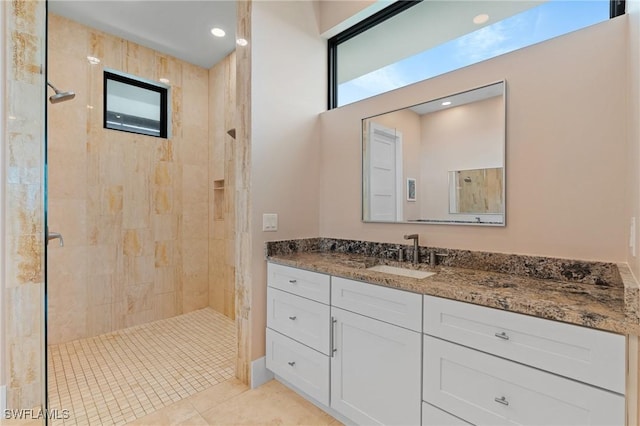 bathroom with vanity, tile patterned flooring, and tiled shower