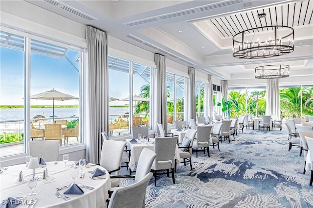 sunroom featuring a water view and a notable chandelier