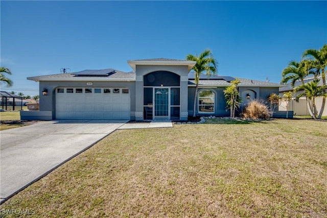 view of front of home with a garage, solar panels, and a front lawn