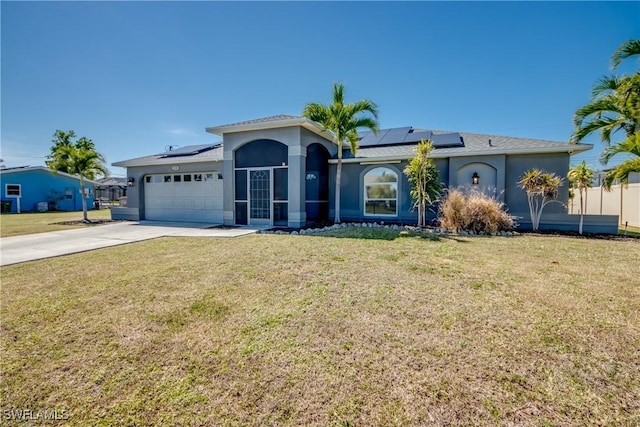 view of front of property featuring a front lawn, solar panels, and a garage