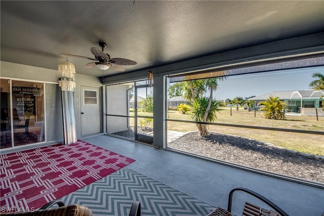 unfurnished sunroom with ceiling fan