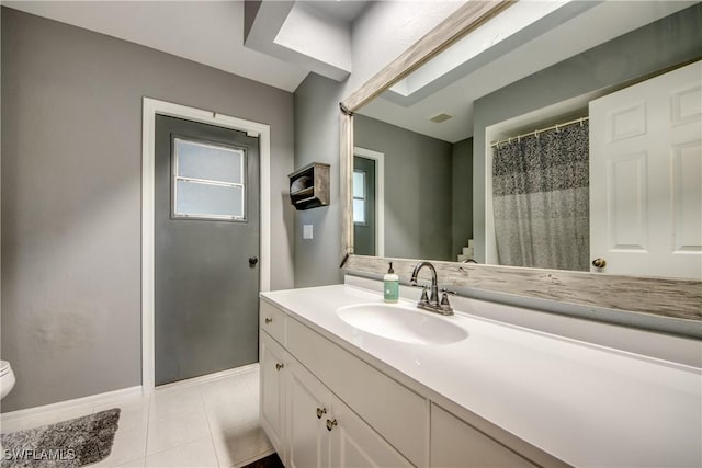 bathroom with tile patterned flooring, vanity, and toilet