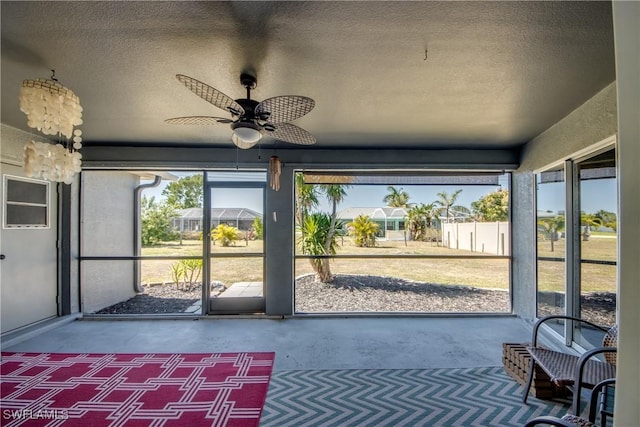 unfurnished sunroom featuring ceiling fan