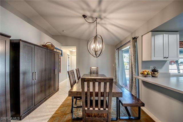 dining area featuring light tile patterned floors, a chandelier, and lofted ceiling