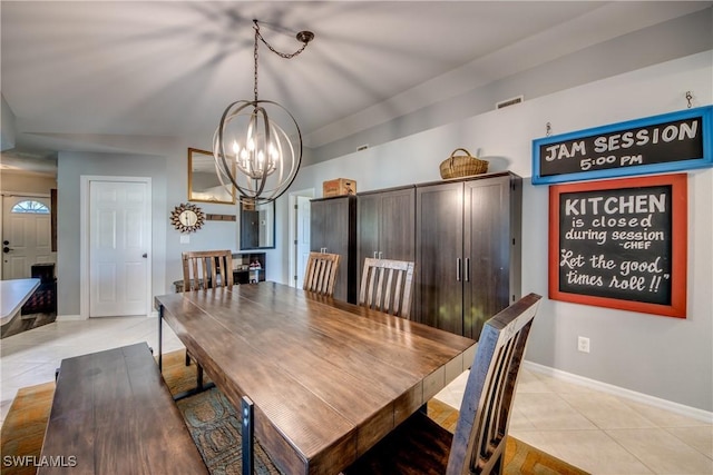 tiled dining room with a chandelier