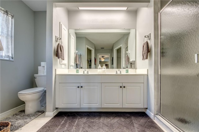 bathroom with toilet, an enclosed shower, and vanity