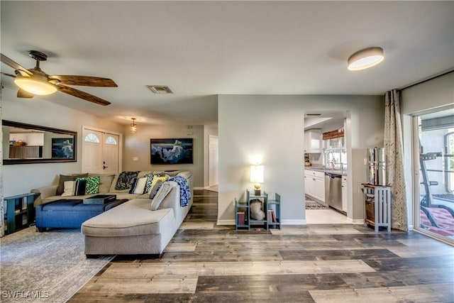 living room featuring sink, hardwood / wood-style floors, and ceiling fan