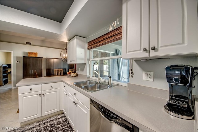 kitchen with white cabinets, light tile patterned floors, sink, and stainless steel dishwasher