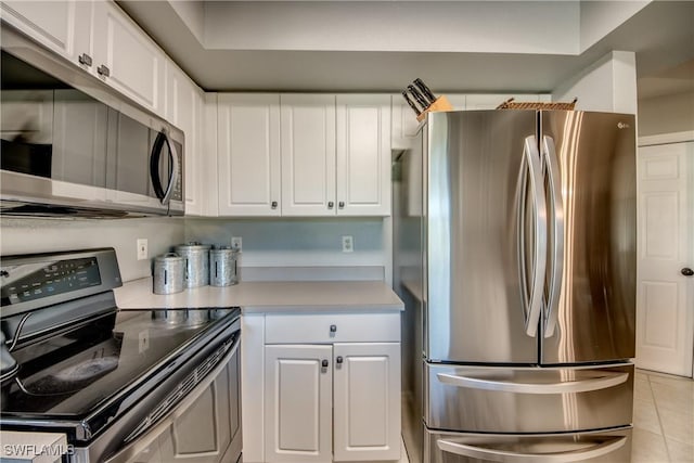 kitchen with light tile patterned flooring, stainless steel appliances, and white cabinets