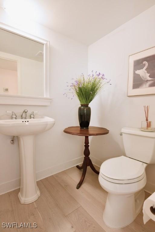 bathroom with hardwood / wood-style flooring, toilet, and sink