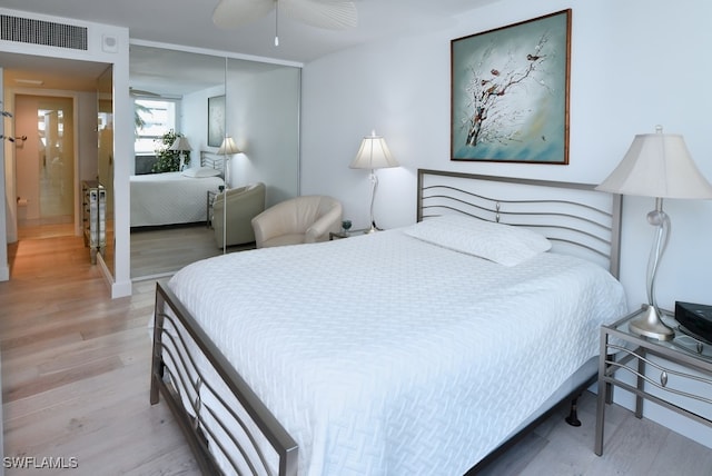 bedroom with a closet, ceiling fan, and light wood-type flooring