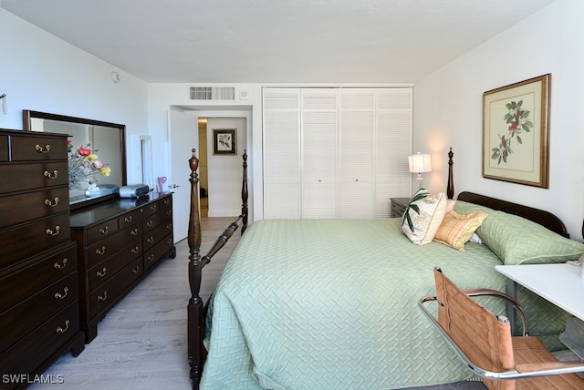 bedroom with light hardwood / wood-style flooring and a closet