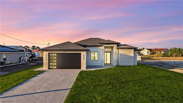 view of front of home featuring a garage and a yard