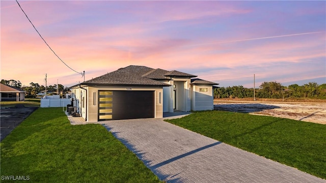 view of front of property with a garage and a lawn