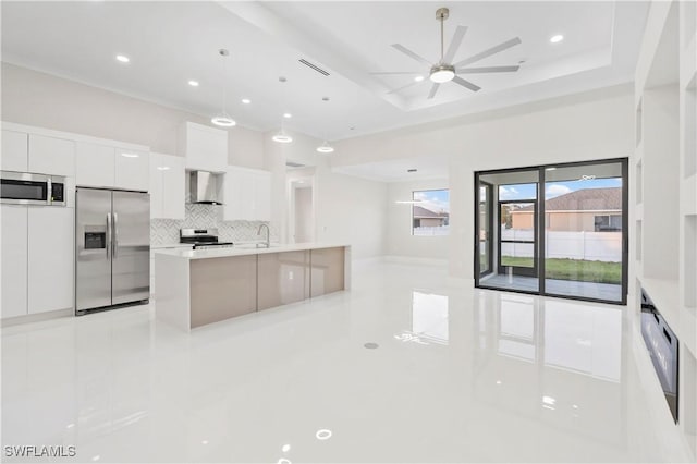 kitchen featuring white cabinets, modern cabinets, stainless steel appliances, light countertops, and wall chimney range hood